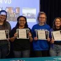 Six students showing their I am GV certificates.